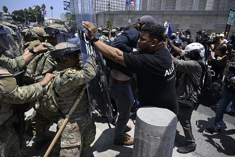 ICE officers and the National Guard clash with protesters Sunday in Los Angeles.