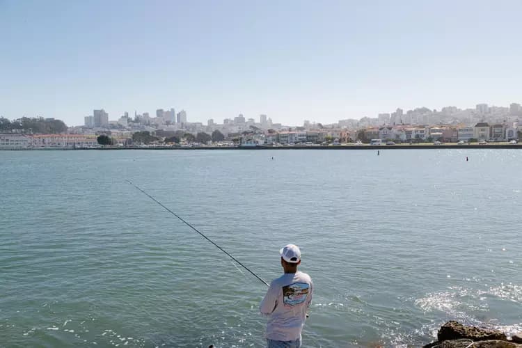 A man fishes on the jetty separating the San Francisco Marina with the bay. A controversial project to extend the harbor at the San Francisco Marina took a step forward Thursday.
