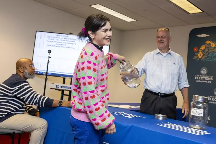Department of Elections Director John Arntz, right, conducts a random drawing to assign letter designations to local measures. The November ballot may be record-breaking long.