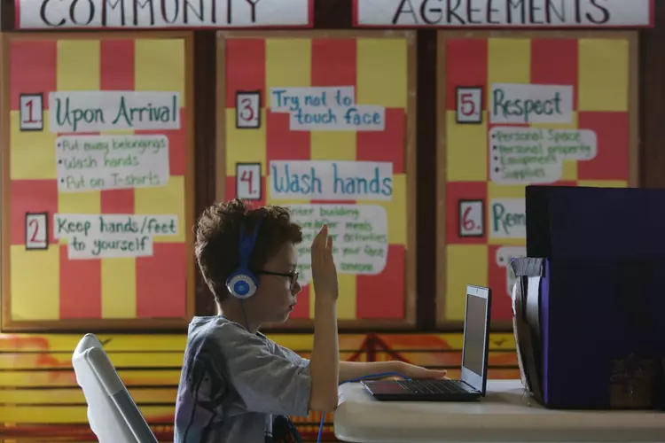 A child attending the emergency child care center at Excelsior Playground in San Francisco works on online learning on May 11, 2020. | Lea Suzuki/The San Francisco Chronicle via Getty Images